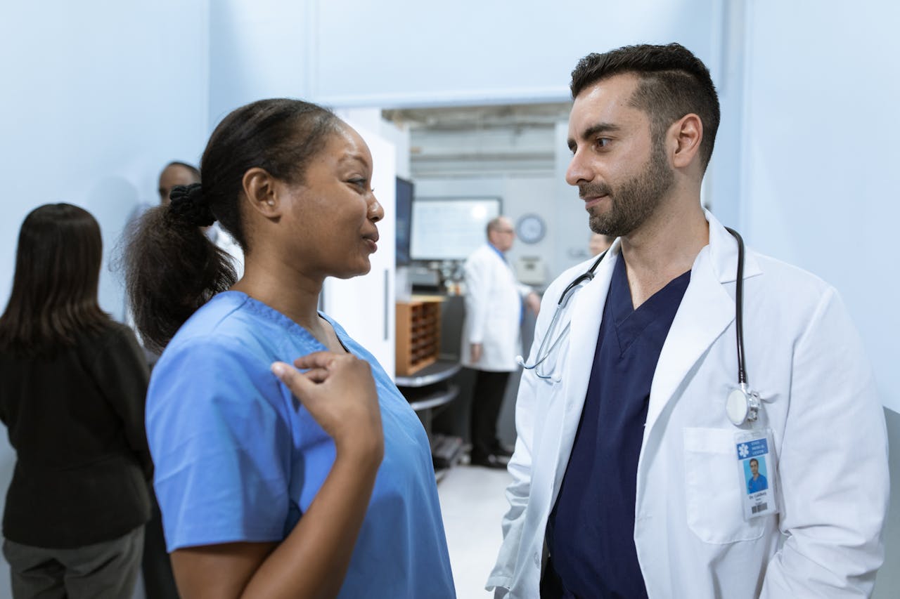 Home Medical professionals discussing patient care in a hospital hallway.
