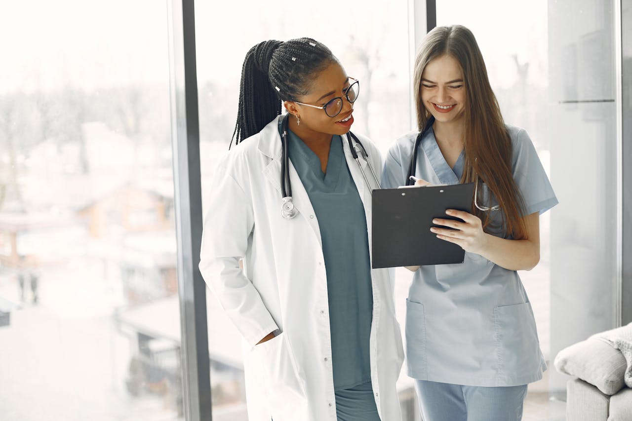 The Art of Drawing Readers In: Your attractive post title goes here Two female healthcare professionals discussing documents in a bright medical setting.